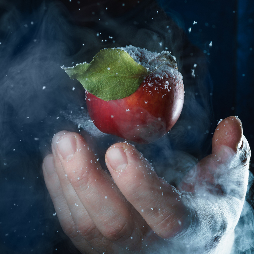 main qui tient une pomme congelée
